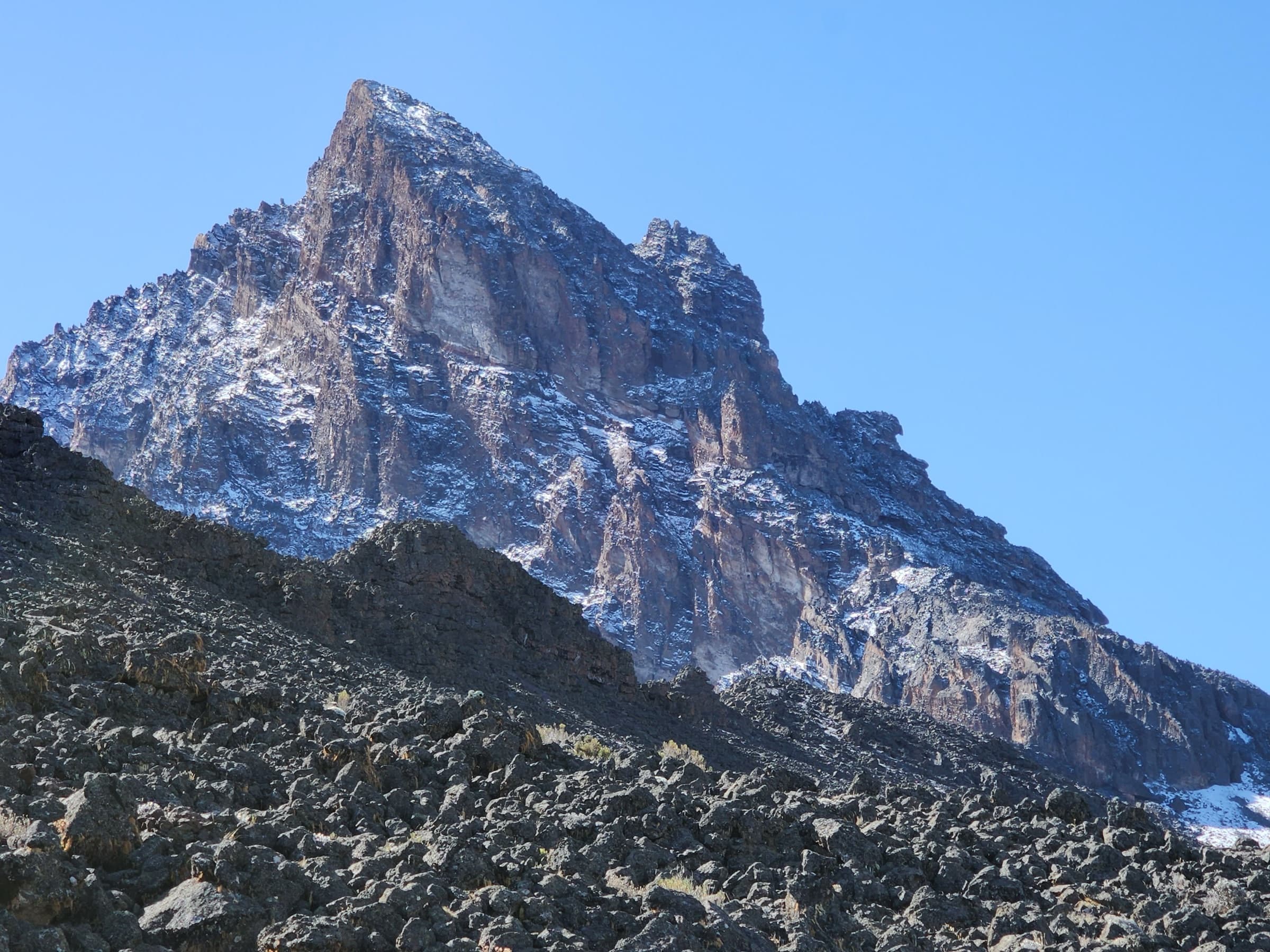 Sharp jagged Mount Kenya summit spire against a clear blue sky